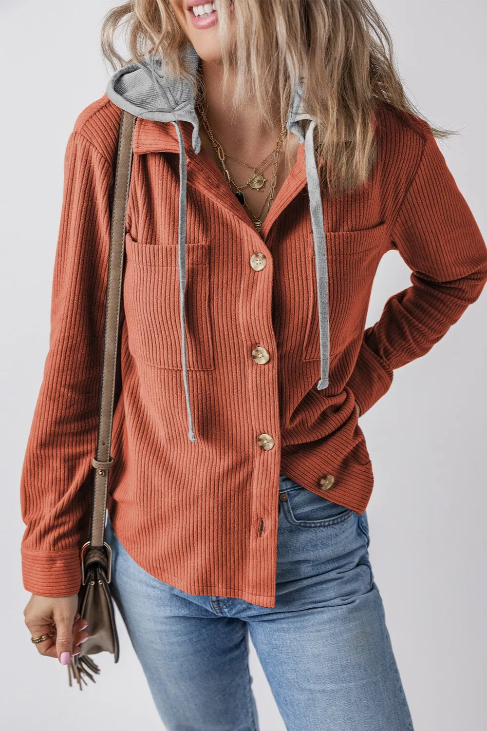 Orange-red ribbed jacket with long sleeves, gray-lined hood, button front and drawcord.