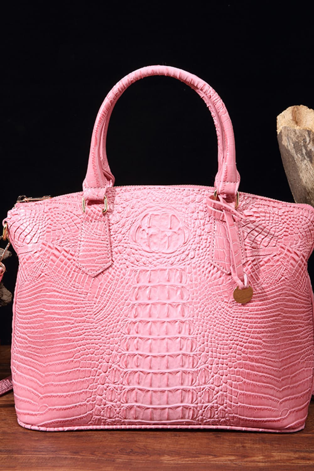 Vegan leather handbag in pink with top handles, embossed crocodile texture, and zipper closure
