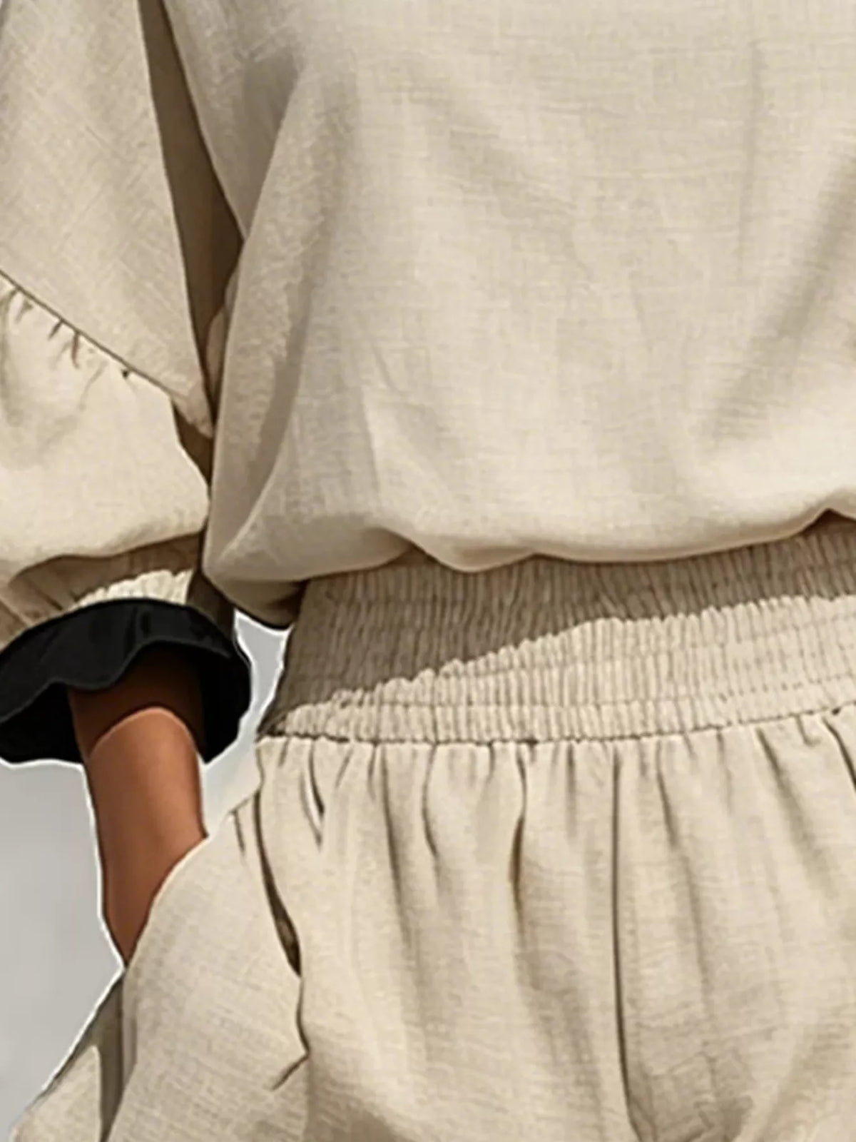 Beige shorts with smocked elastic waistband and black contrast ruffle trim