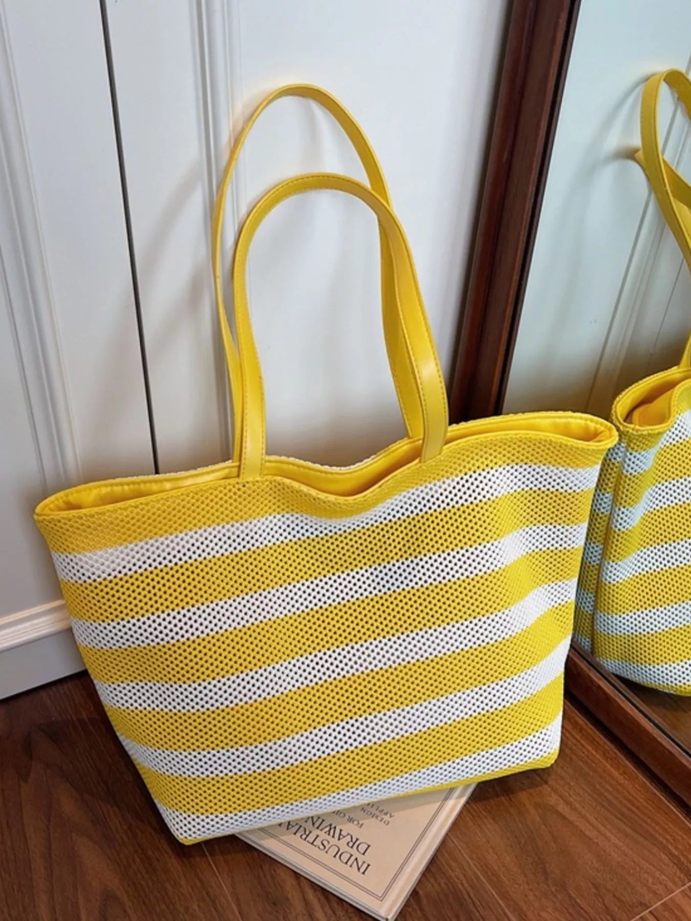 Yellow and white striped mesh shoulder tote with long handles, open top