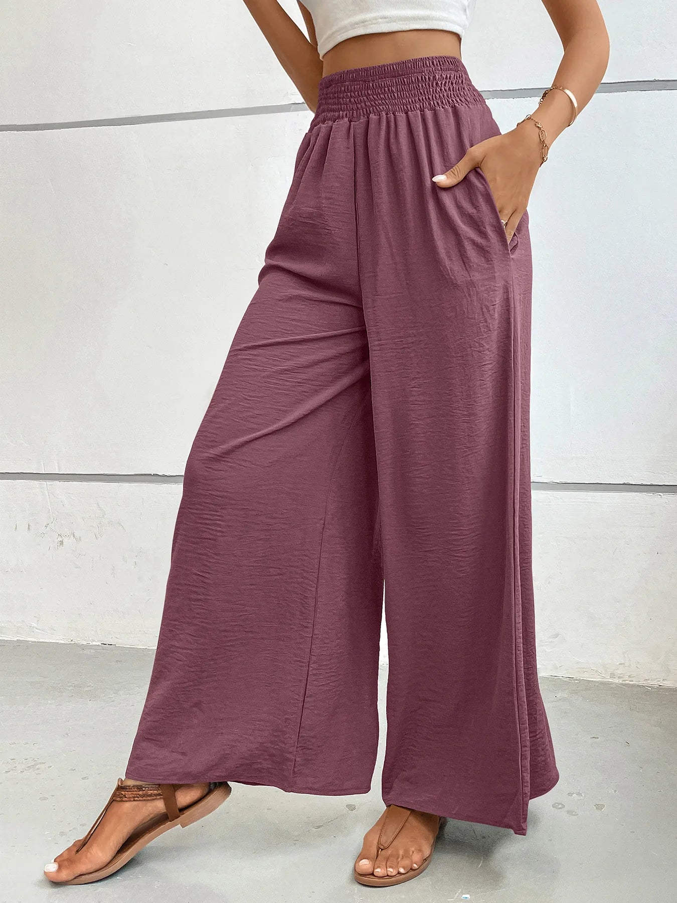 High-waisted wide-leg pants in dusty plum with elastic smocked waistband and relaxed wide legs.
