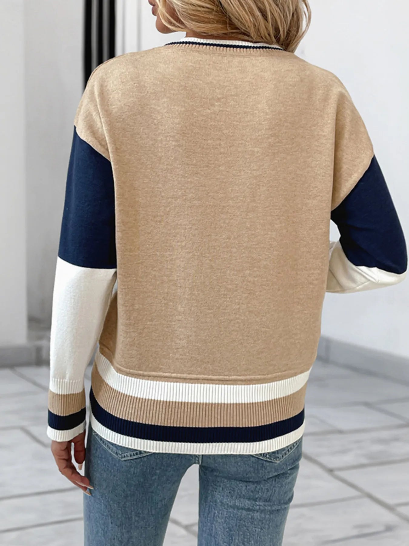 Back view of color block round-neck sweater with ribbed hem; beige with navy sleeves