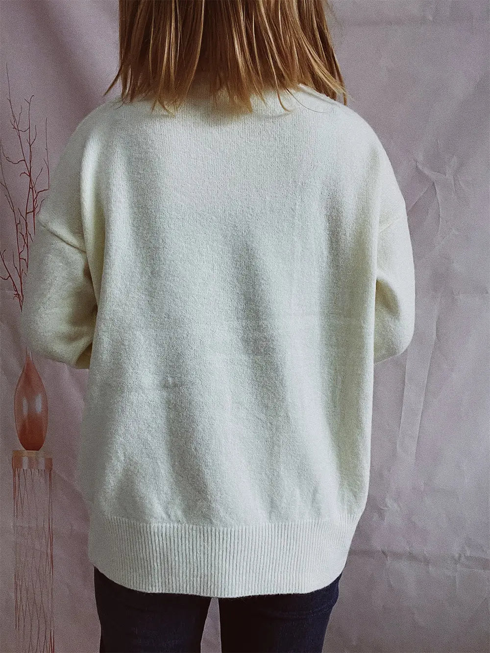 Turtleneck long-sleeve sweater in cream, back view, ribbed collar and cuffs.