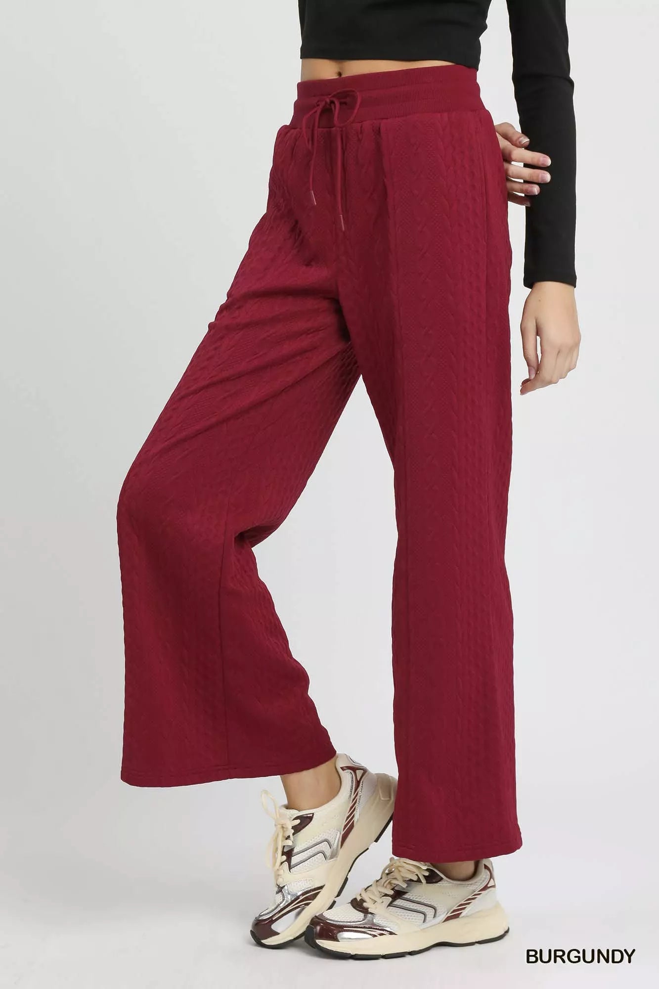 Burgundy textured wide-leg pants with tie waist and relaxed drape