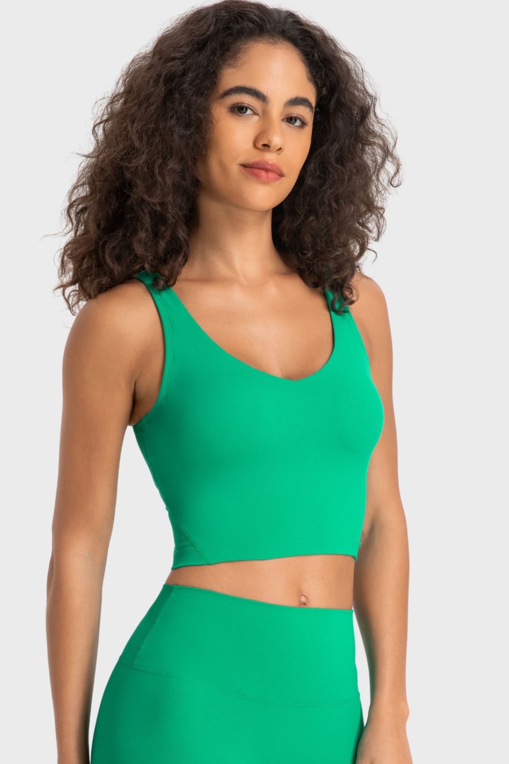 Deep V-neck crop sports bra, bright green color, front view with neckline details.