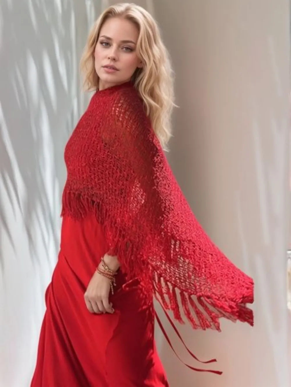 Red boat neck knit shawl with long tassel fringe, draped over shoulders
