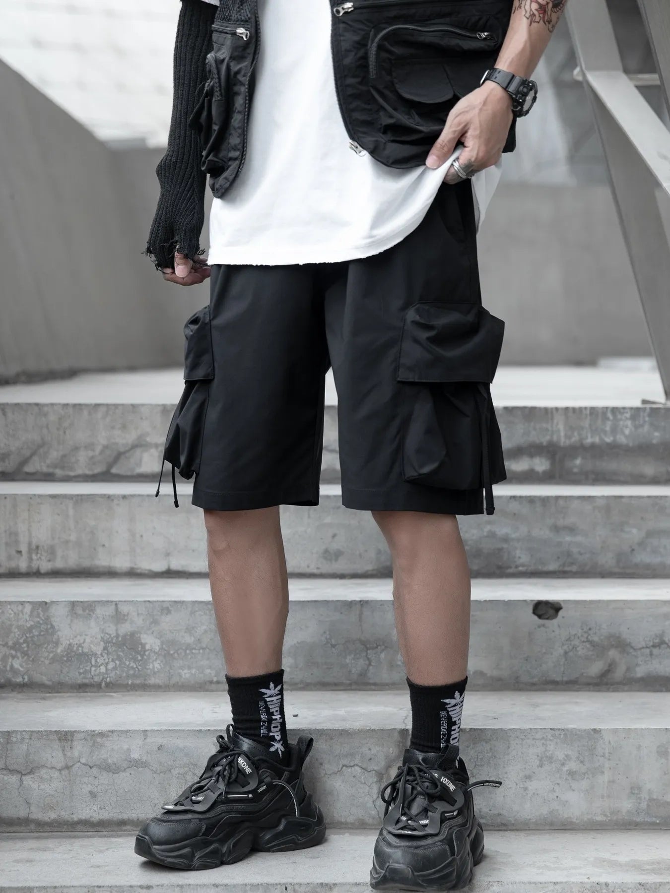 Black cargo shorts with flap pockets, relaxed fit, and drawstring waist