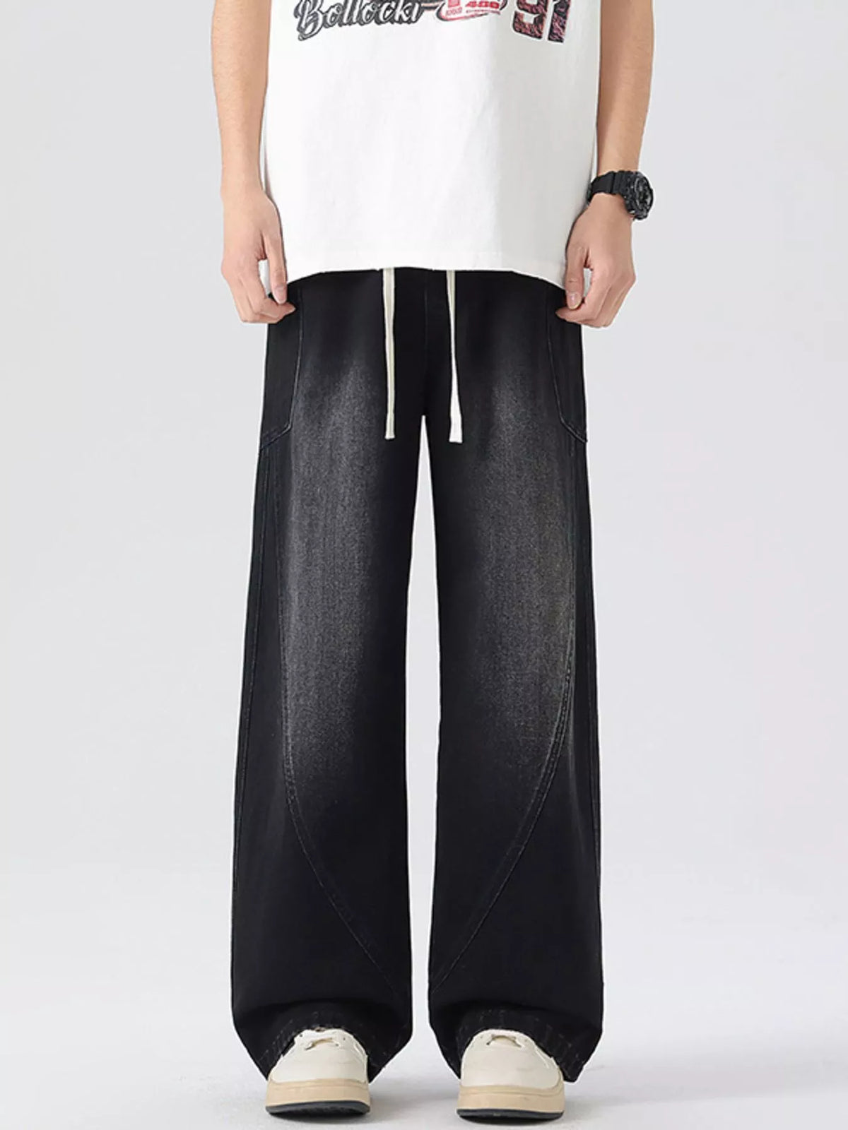 Men's vintage wide-leg jeans in black denim with drawstring waist and relaxed fit.