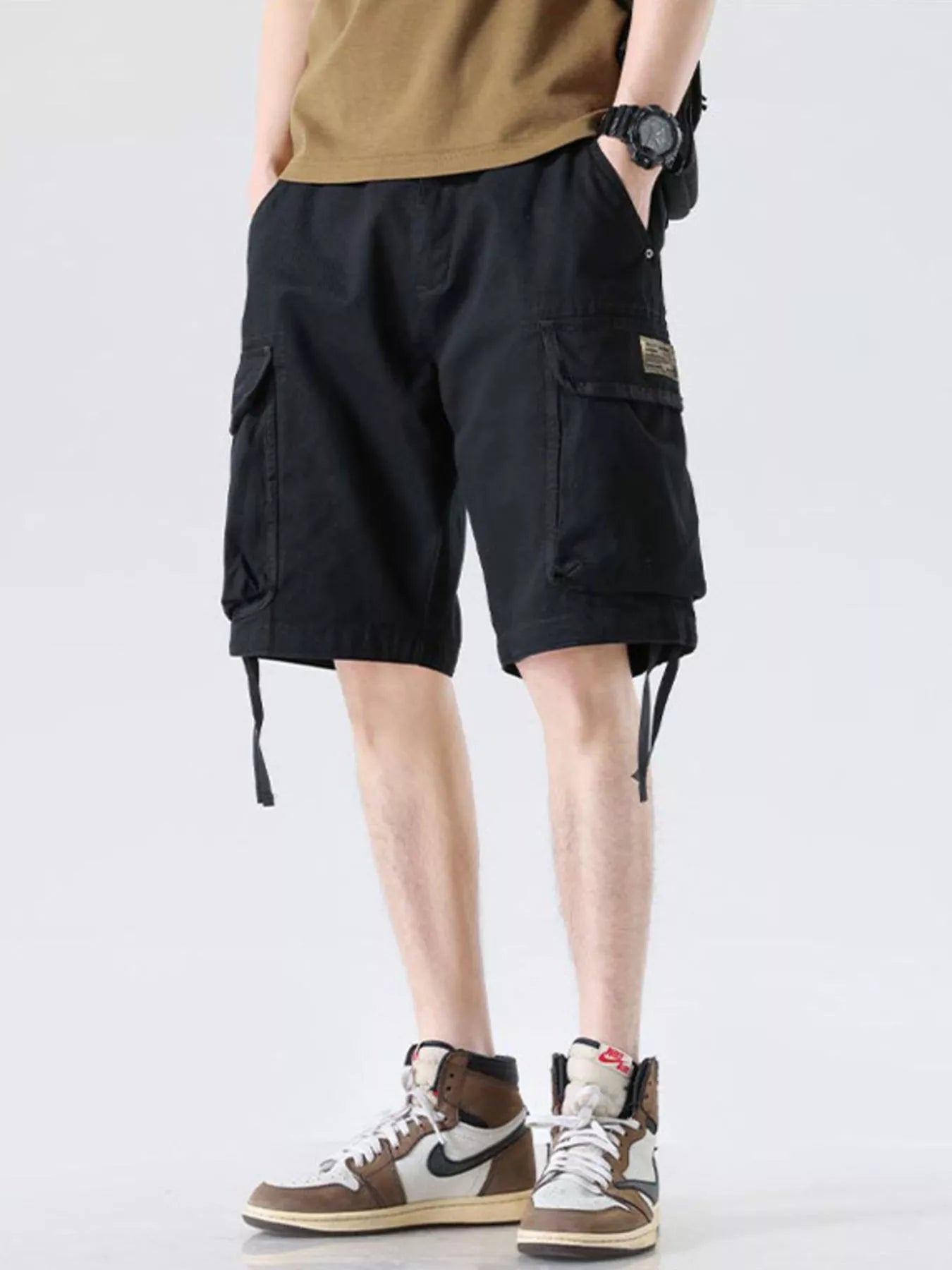 Black cargo shorts with drawstring waist and side cargo pocket, wide-leg hem ties