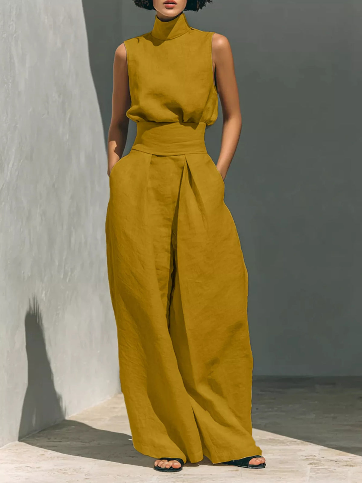 Sleeveless wide-leg jumpsuit in mustard yellow with smocked waist and high neckline