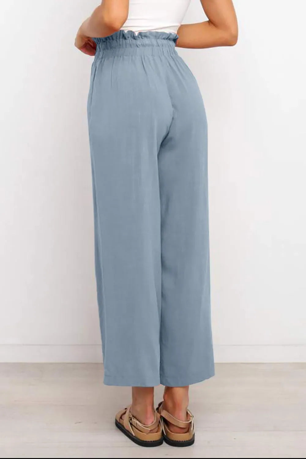 Light blue wide-leg pants with drawstring paperbag-style waist, shown from the back