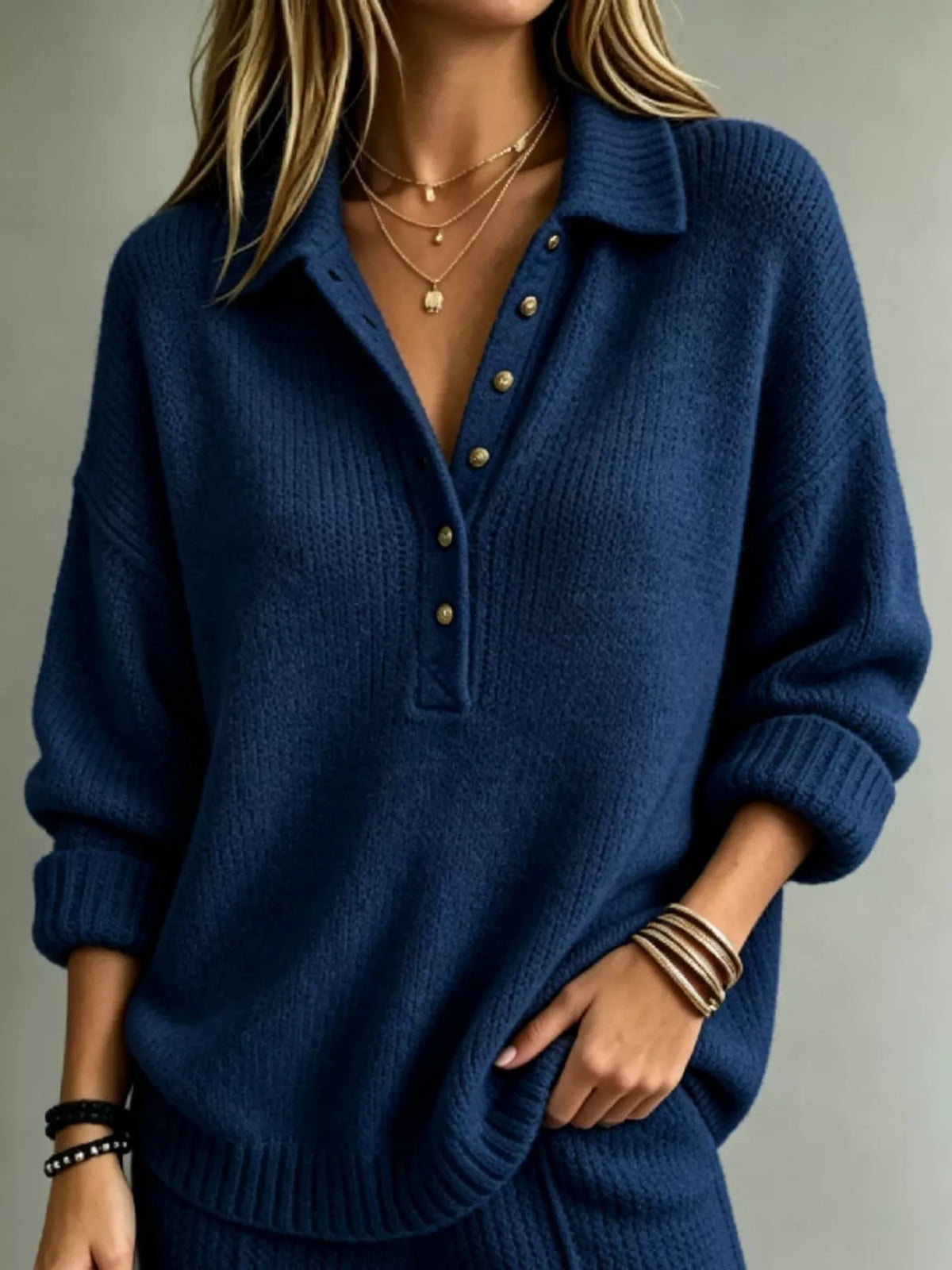 Blue button-front dropped-shoulder sweater with henley placket and ribbed cuffs.