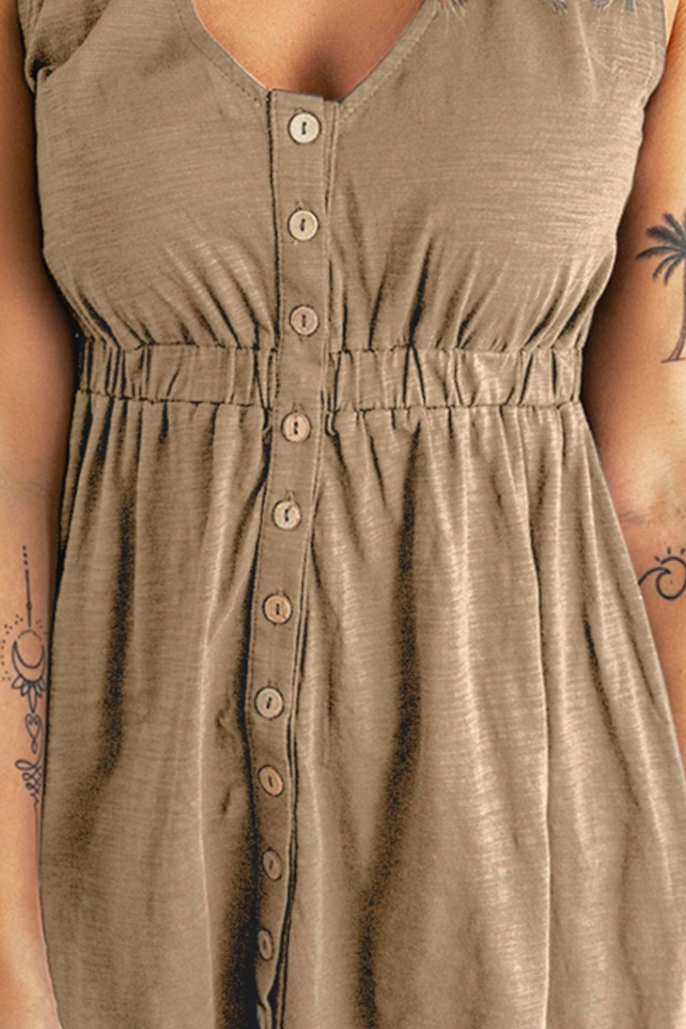 Close-up of brown sleeveless mini dress bodice with button placket and gathered waist