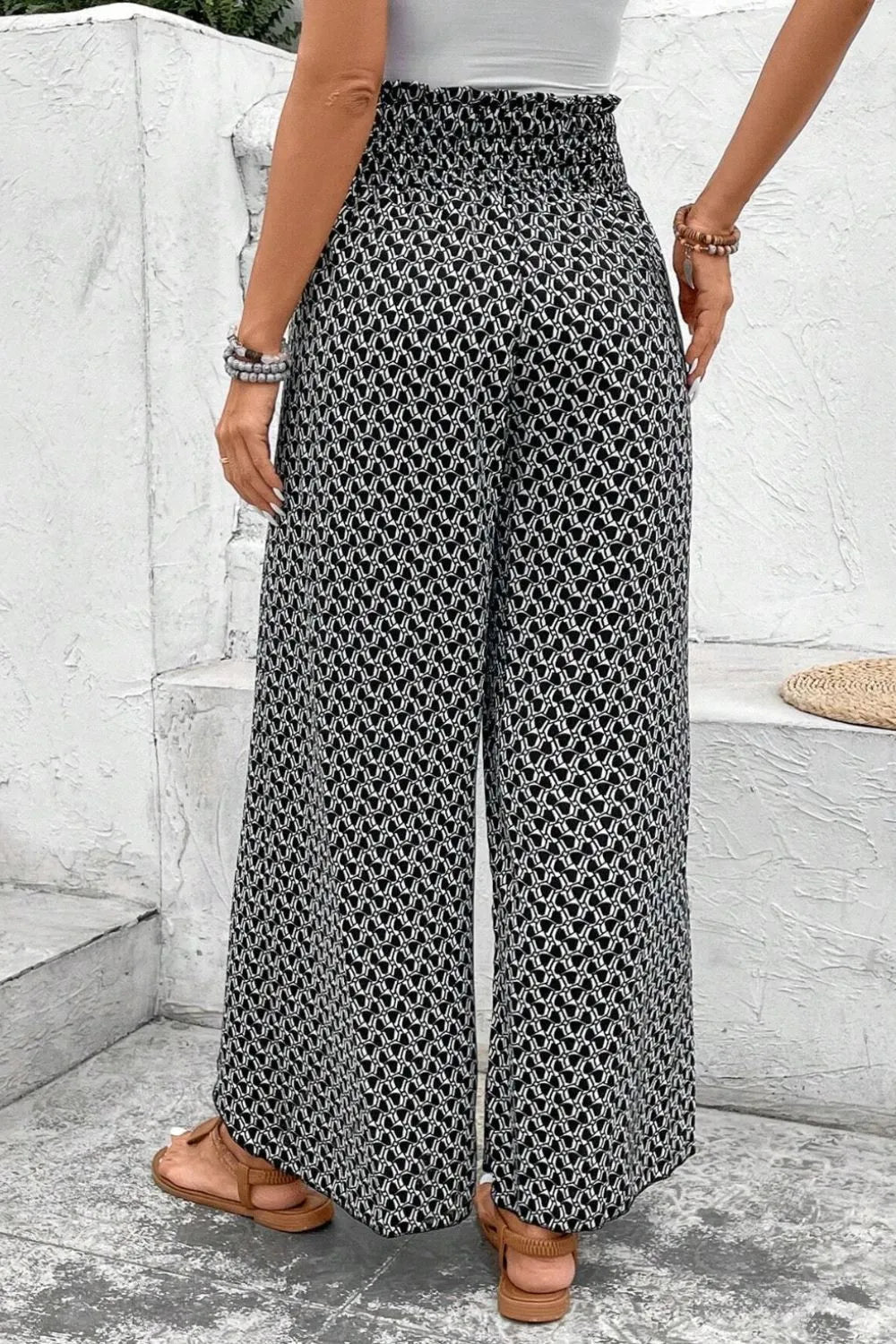 Black patterned wide-leg pants with elastic waist and front slit detail