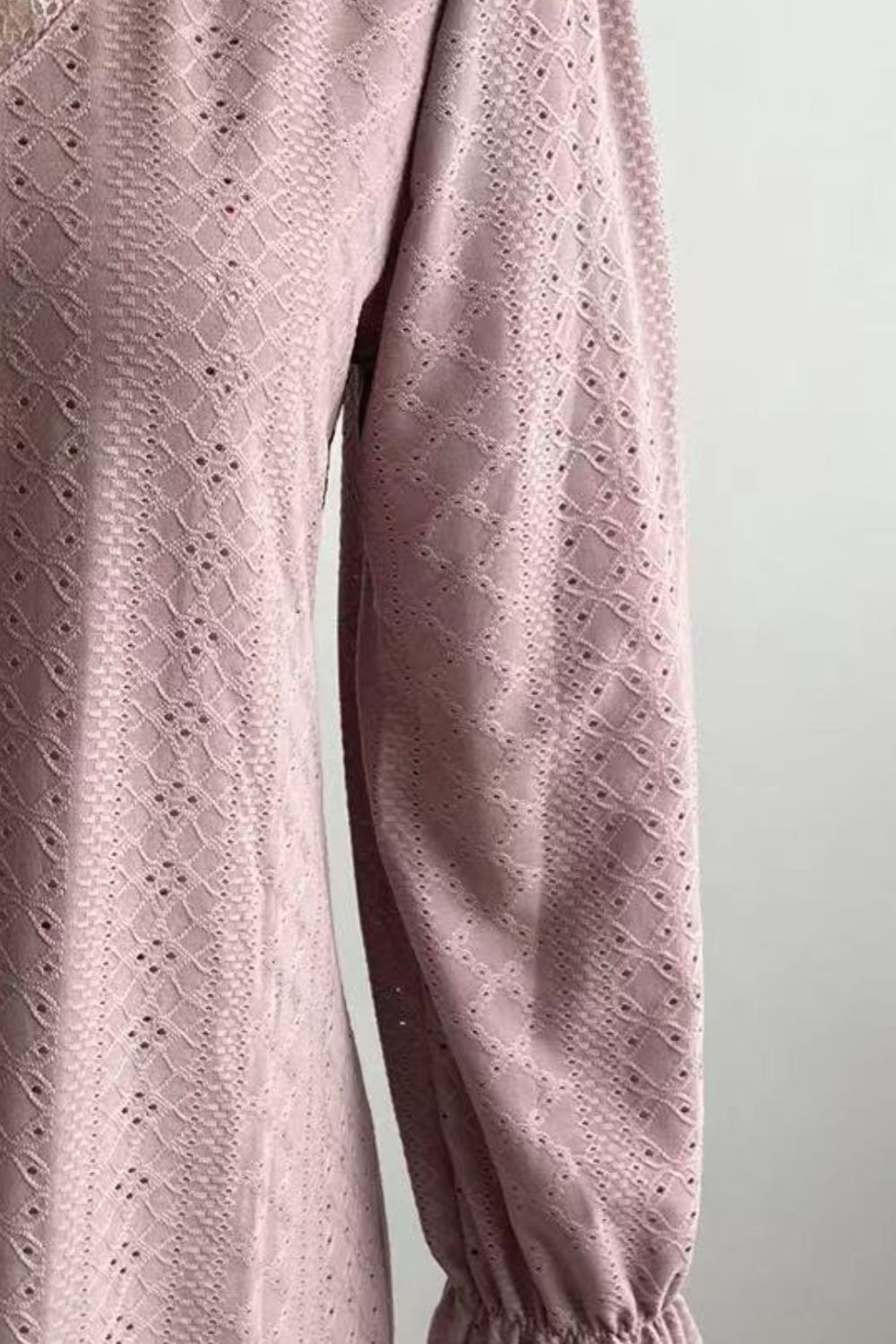 Lavender eyelet fabric blouse detail with puff sleeves and textured cutouts