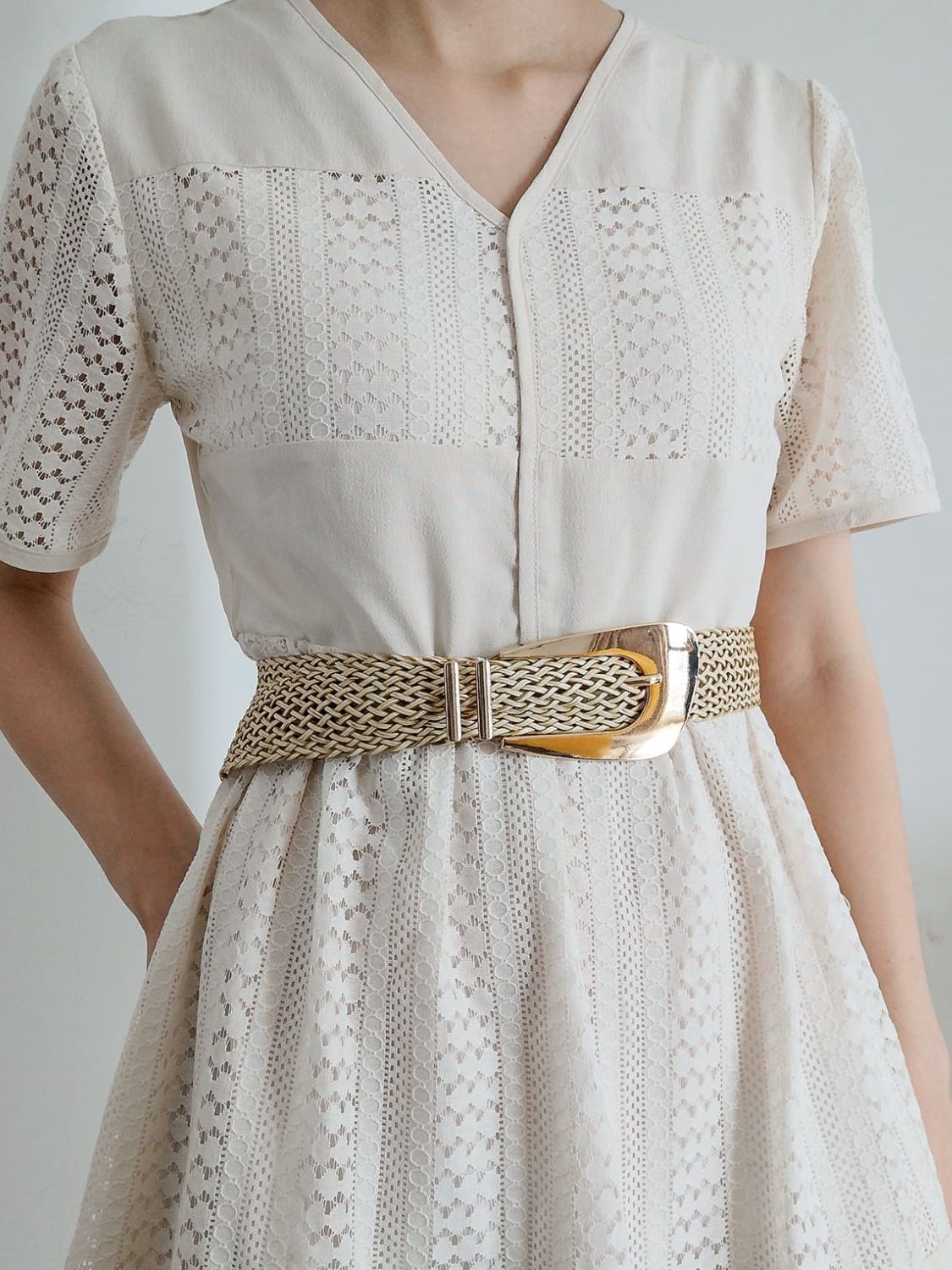 Woven braid belt with gold-tone irregular buckle on a white dress waist