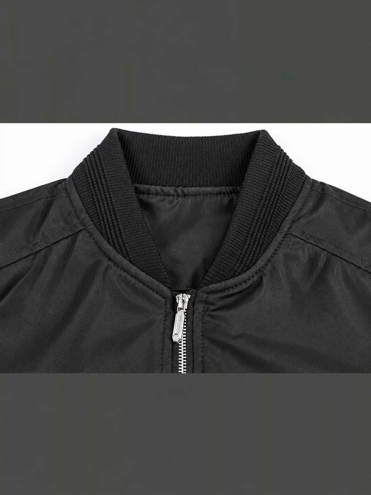 Men's black bomber jacket close-up, stand collar with metal zipper and ribbed trim