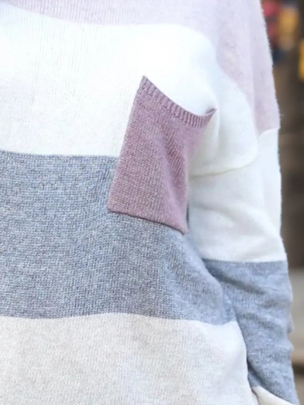 Striped sweater sleeve detail with lavender pocket panel and white-gray blocks