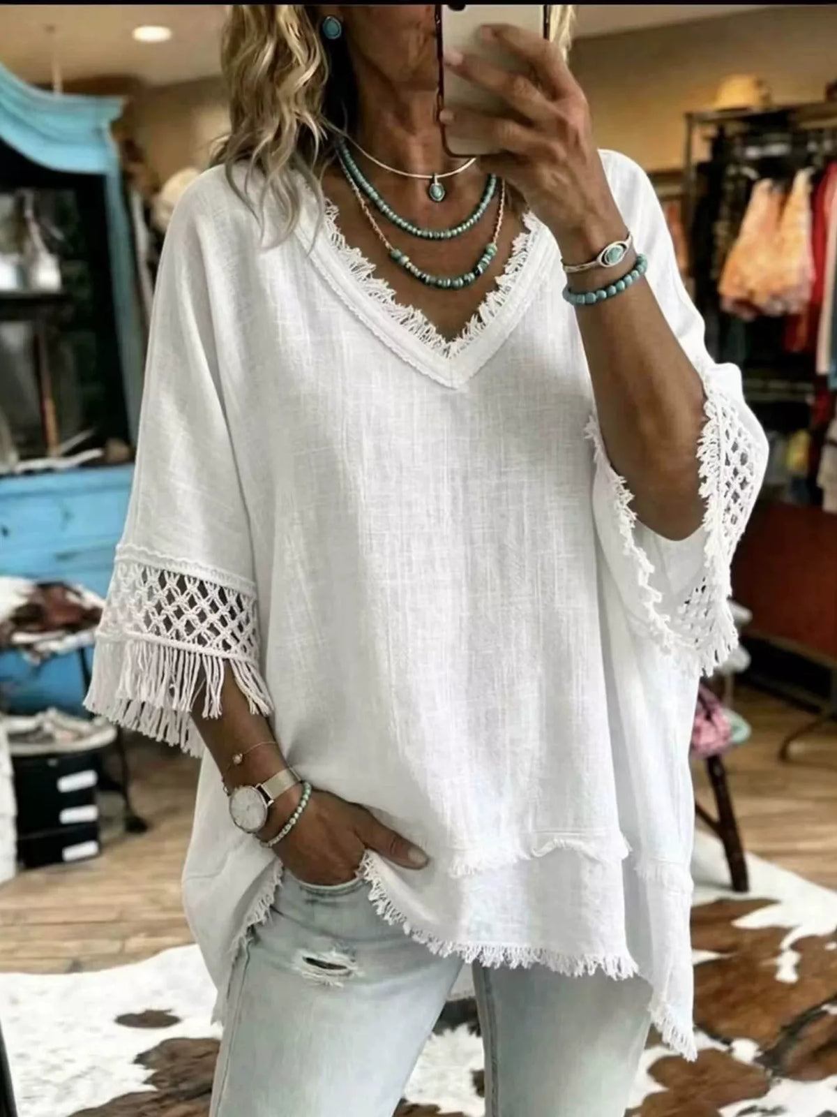 White loose V-neck blouse with fringe trim and crochet lace sleeve edges
