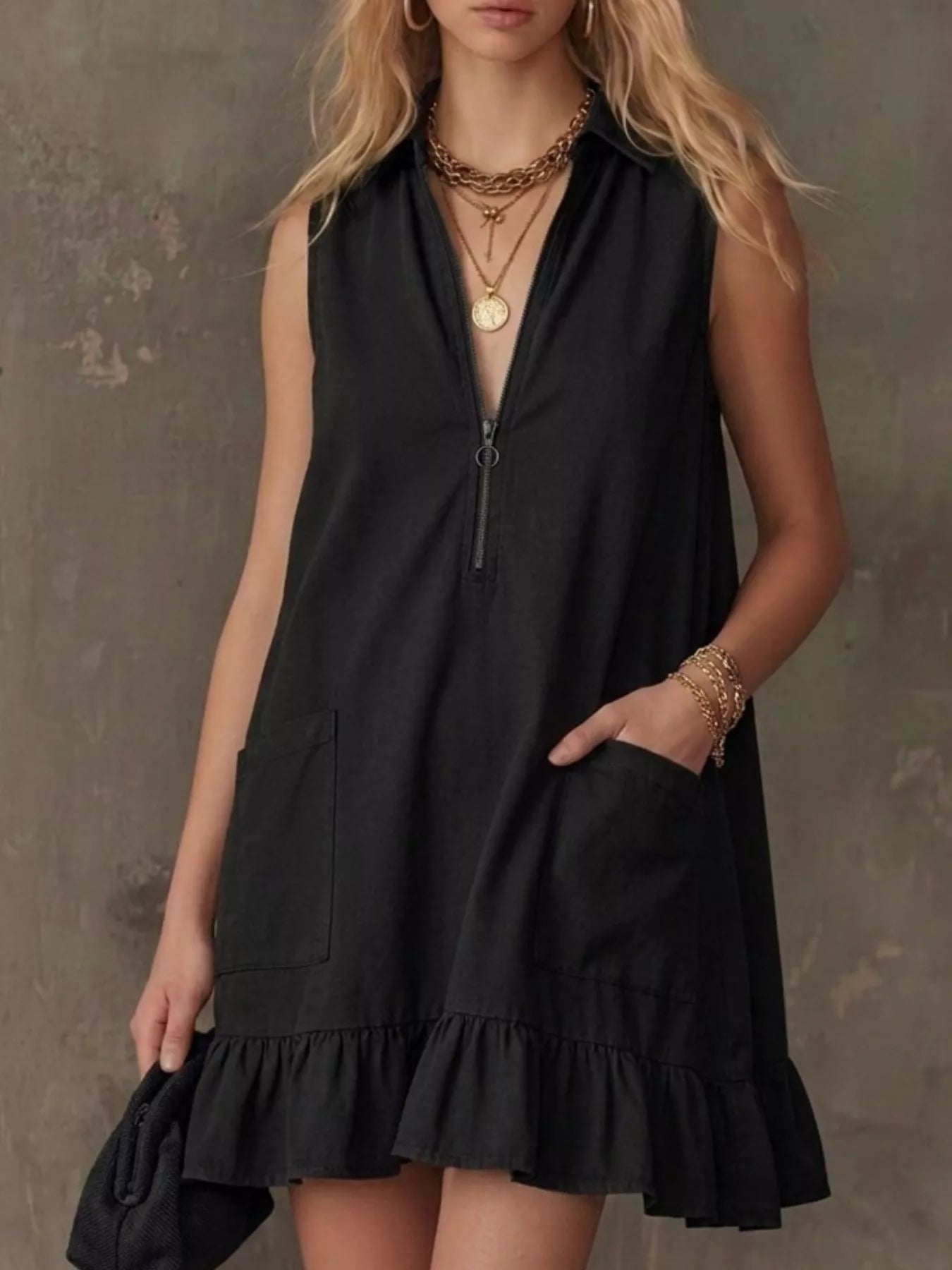 Black sleeveless collared zip-front ruffle hem dress with front zip and pockets