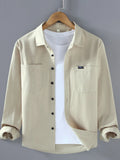 Beige long sleeve button-up shirt with chest pockets and button front