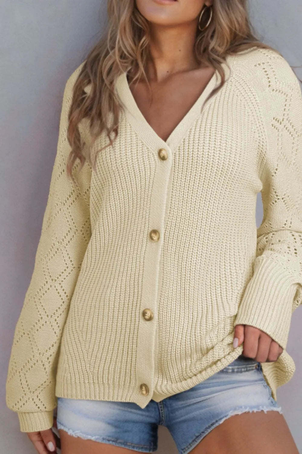 Cream openwork knit V-neck button-up cardigan with long sleeves and front button closure