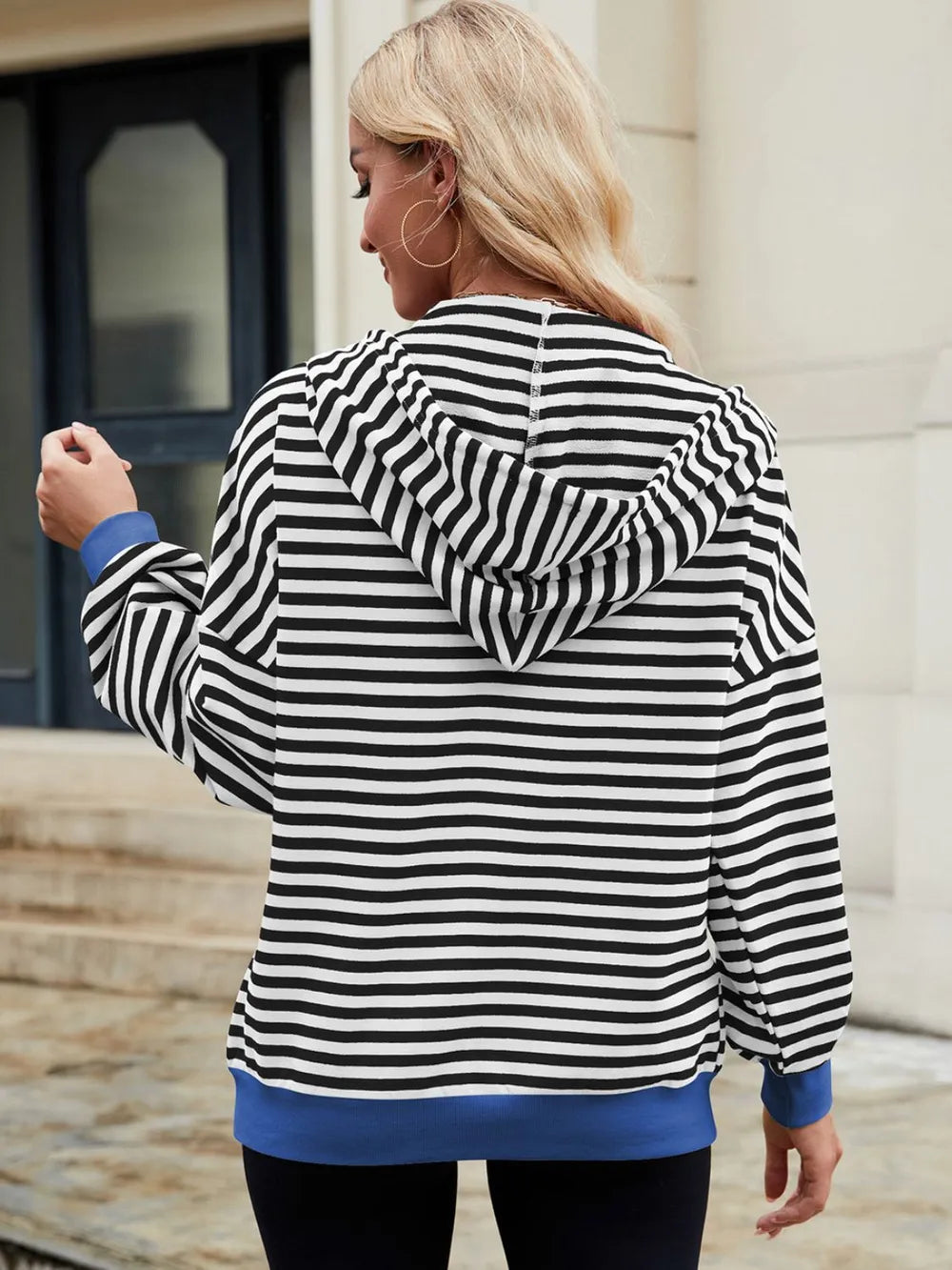 Black-and-white striped zip-up hoodie with hood and drawstring, long sleeves.