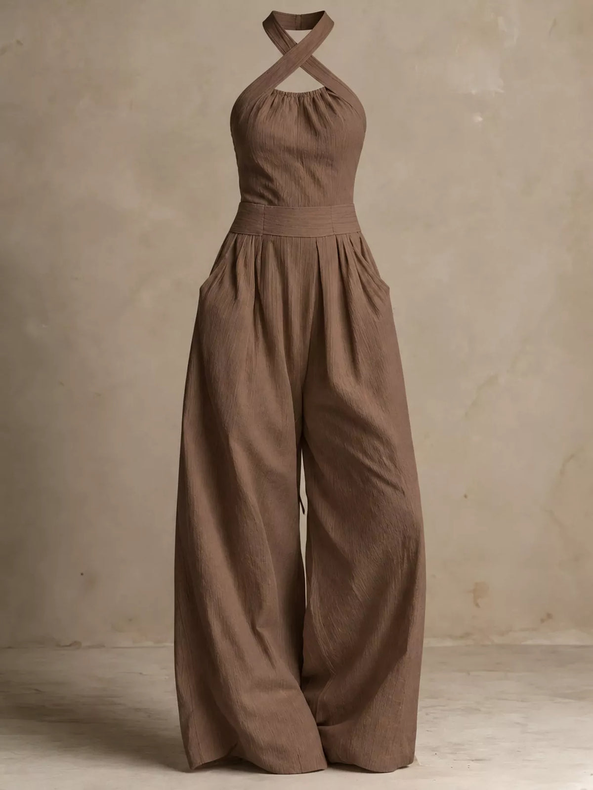 Mocha halter linen jumpsuit with crisscross back straps and flowing wide legs