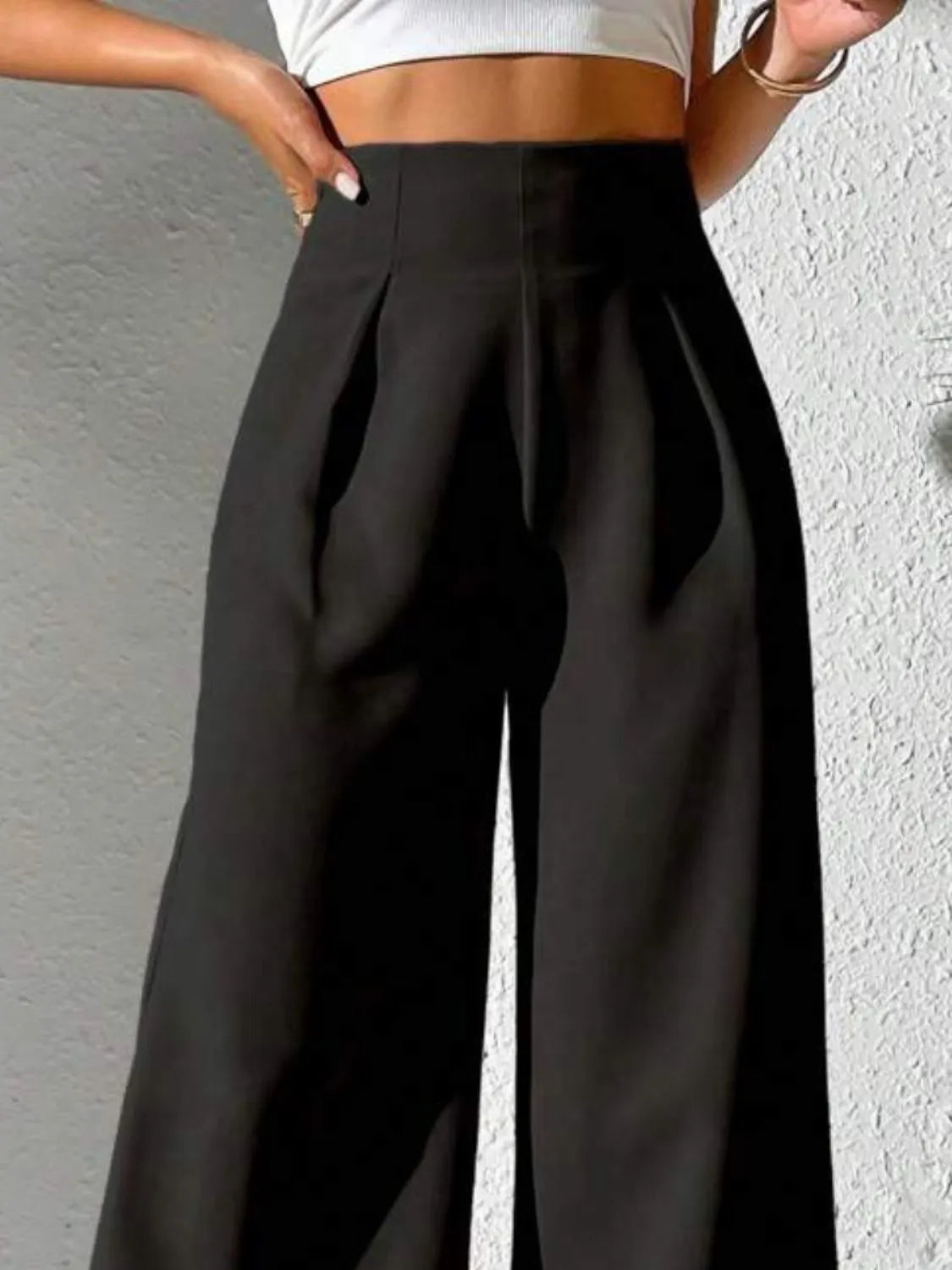 Black high-waist wide-leg pants with deep pleats at the front