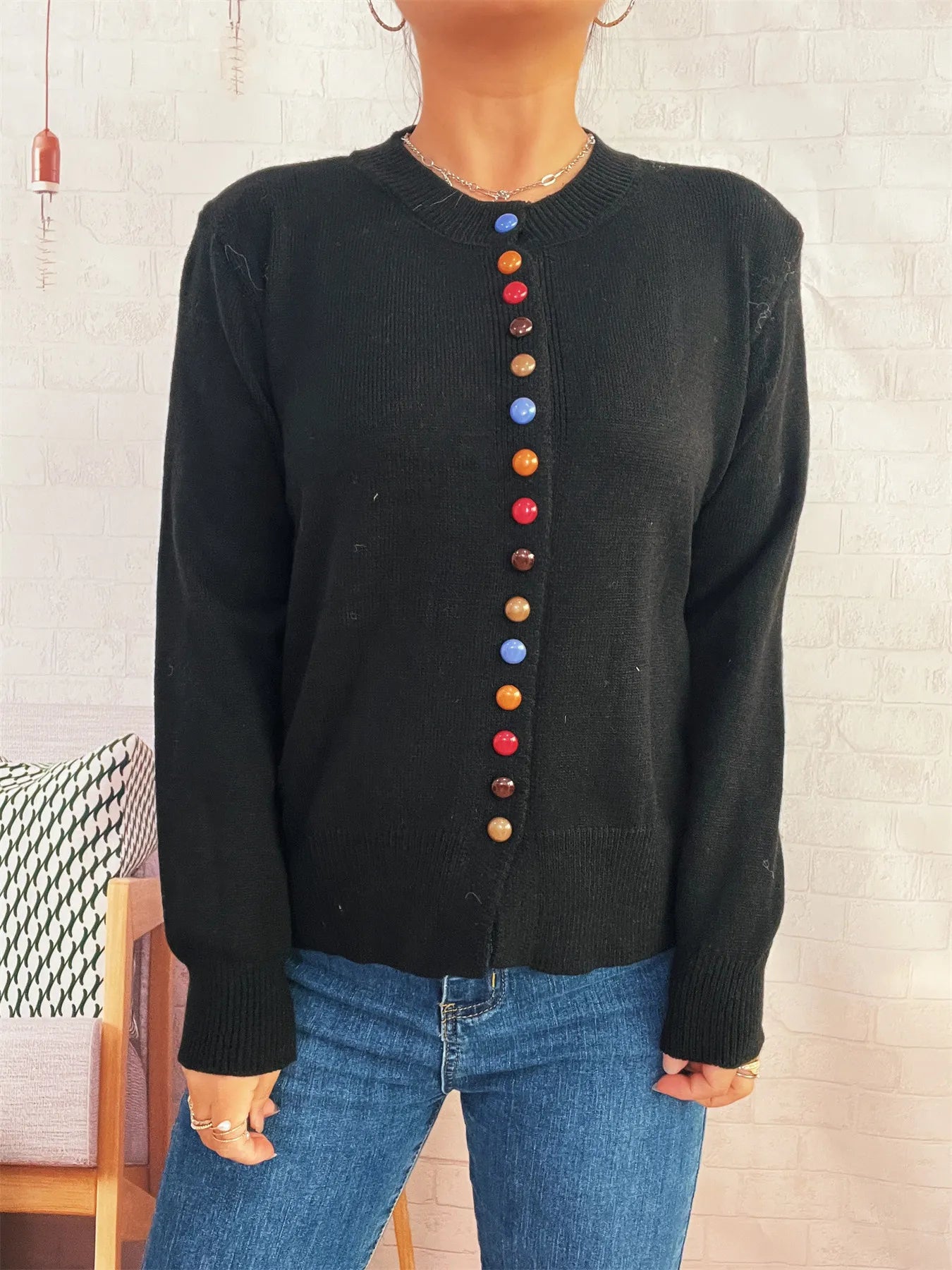 Black button-front cardigan with colorful detail buttons, crew neckline, long sleeves