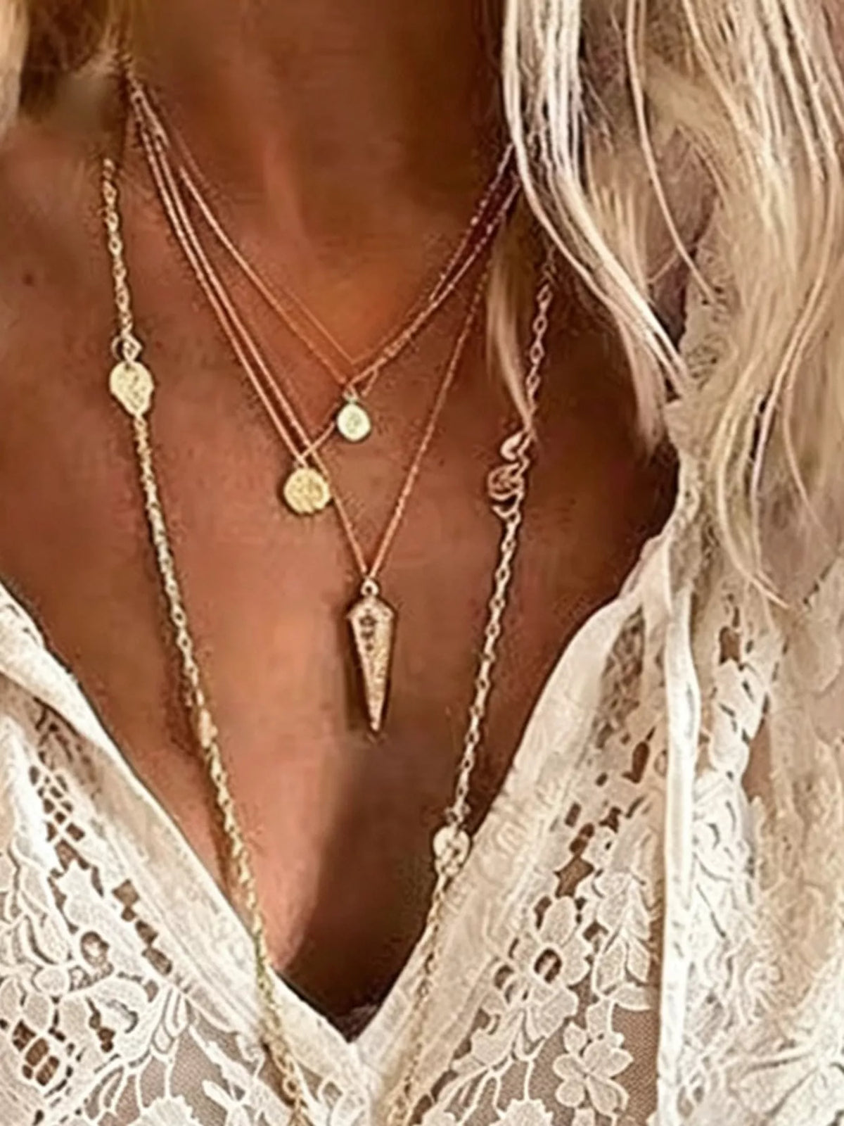 White lace V-neck blouse close-up with scalloped openwork trim
