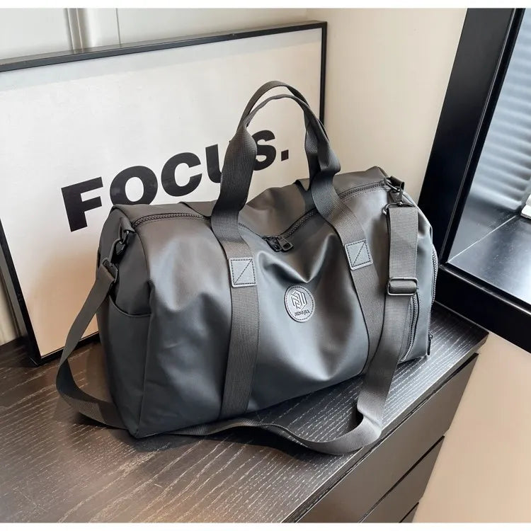 Dark gray large waterproof duffel bag with black handles and front zipper pocket