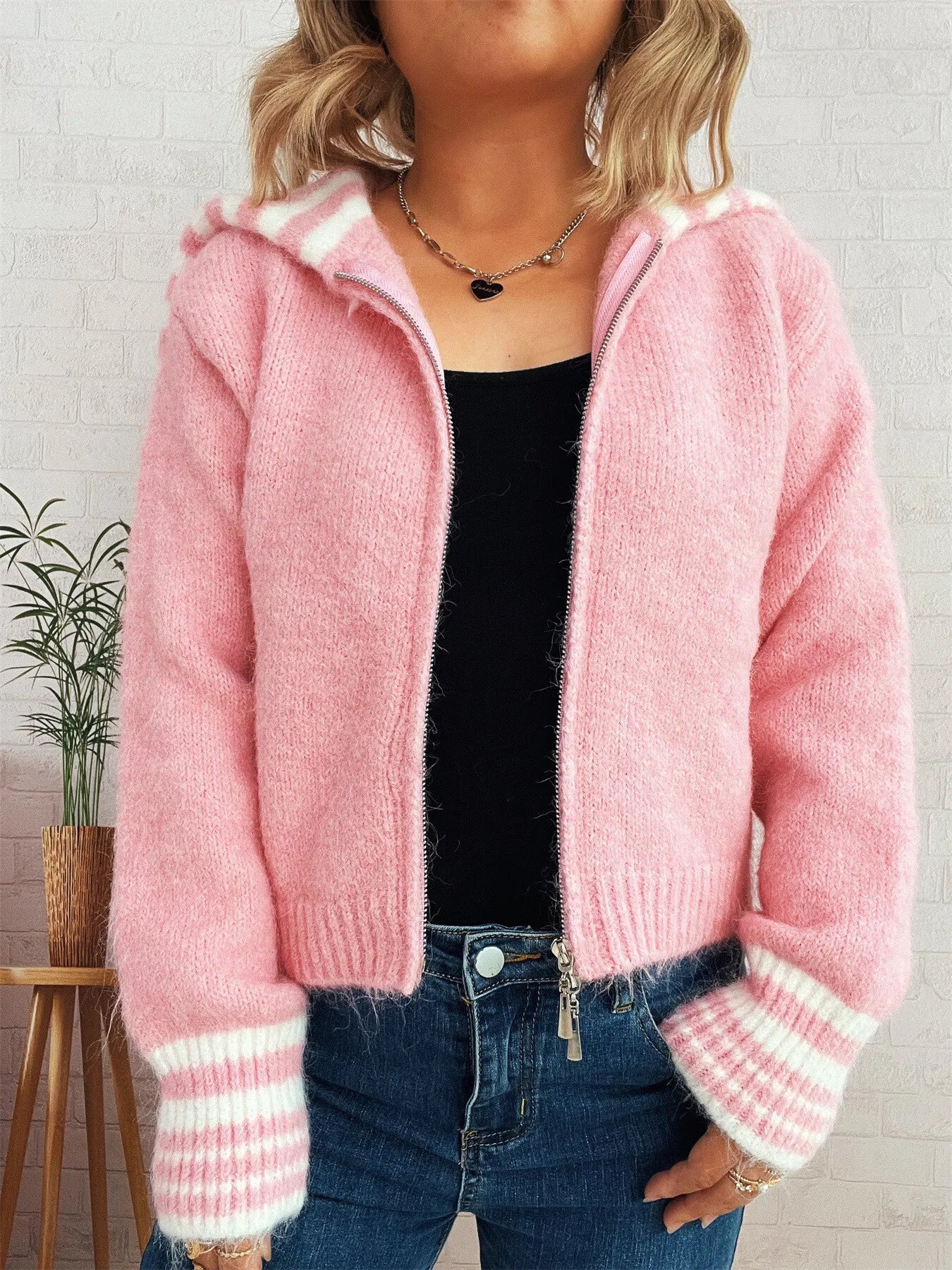 Pink fuzzy zip-up cardigan with striped sleeve cuffs and open collar