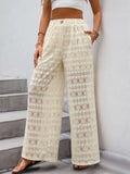 Cream wide-leg lace pants with decorative button waistband and allover geometric pattern