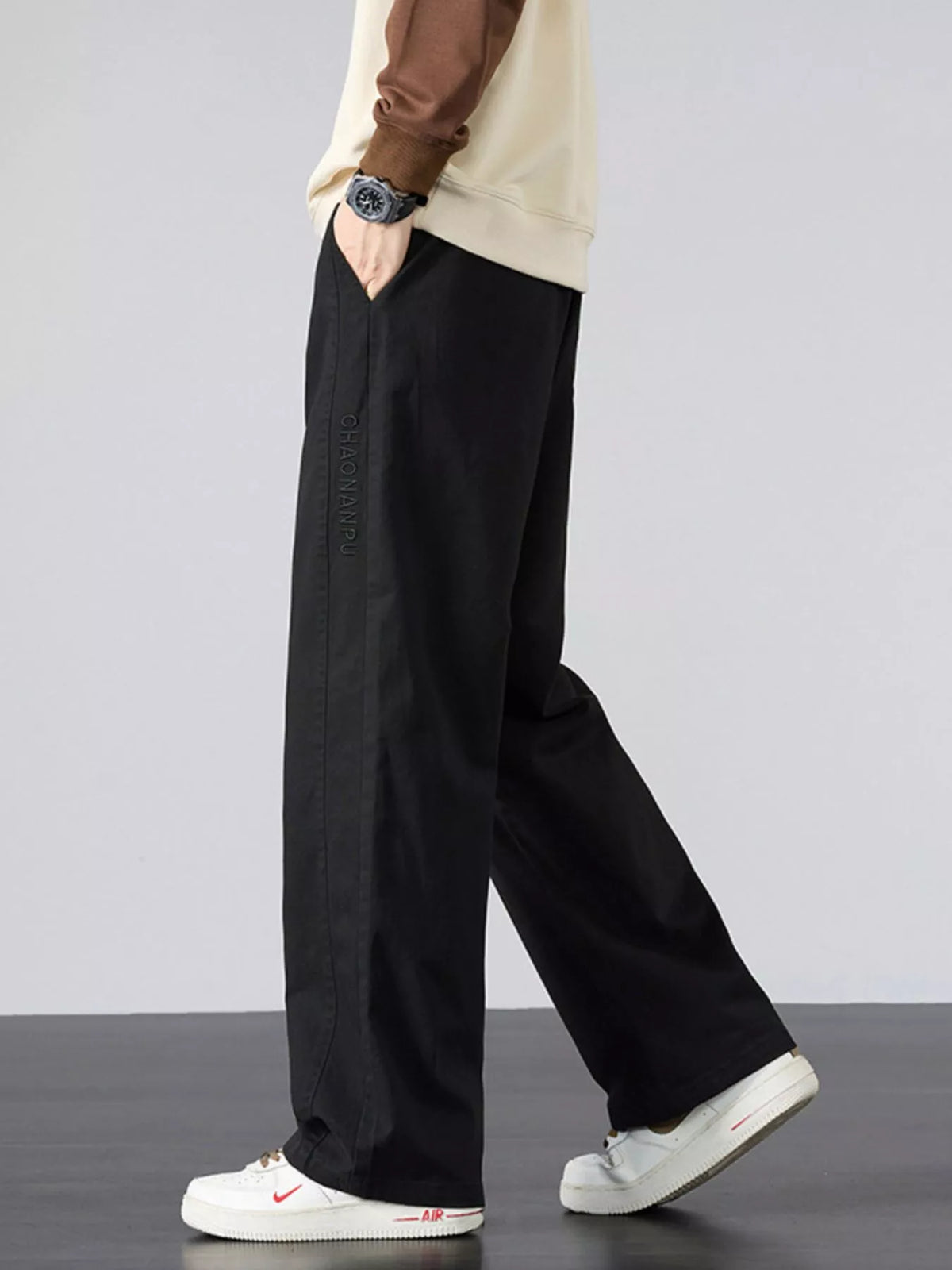 Mens black wide-leg pants with elastic waistband, white drawstring, and side pockets