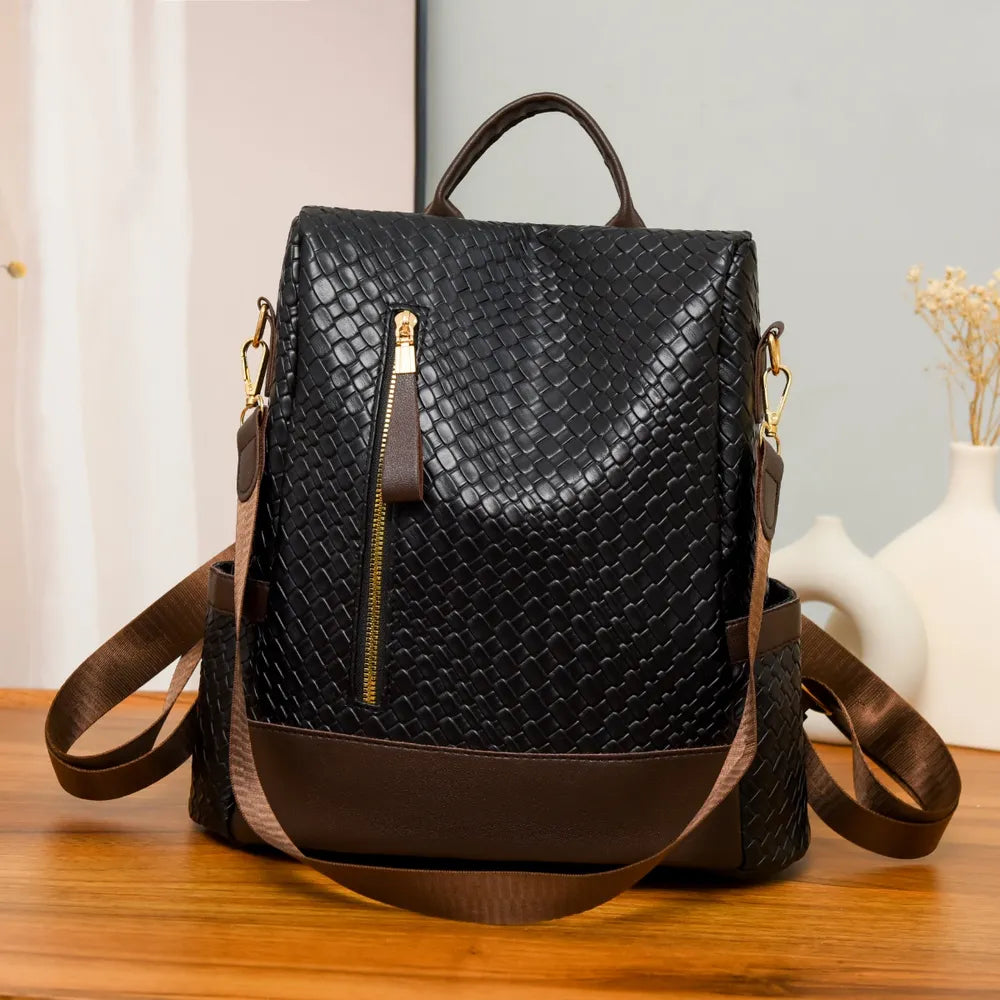 Vegan leather backpack bag in black with brown bottom panel and front zip pocket
