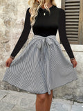 Black round-neck long-sleeve dress with striped flare skirt and tied waist bow