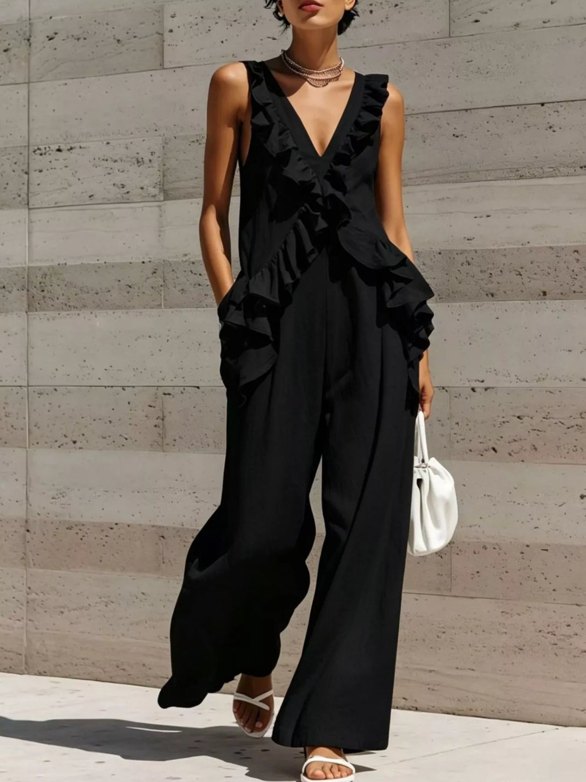 Black ruffled V-neck sleeveless jumpsuit with tiered ruffle detailing and wide-leg pants