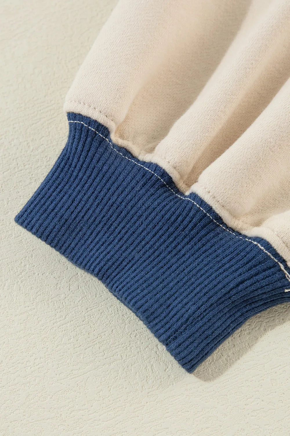 Ivory sweatshirt cuff with dark ribbed contrast band