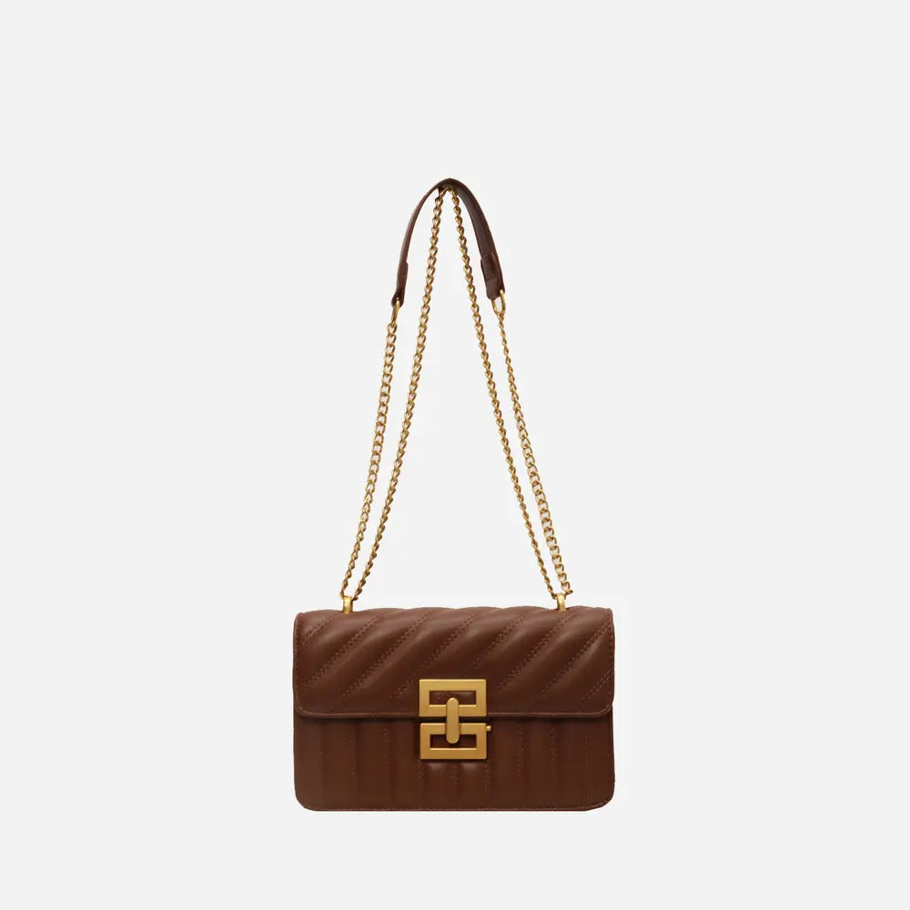 Brown vegan leather crossbody bag with gold chain strap and front flap logo clasp.