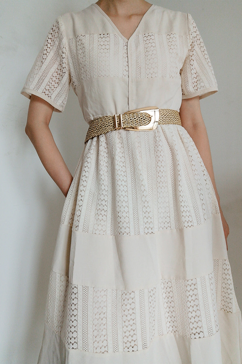 Woven braid belt with gold-tone irregular buckle, styled at the waist on a dress