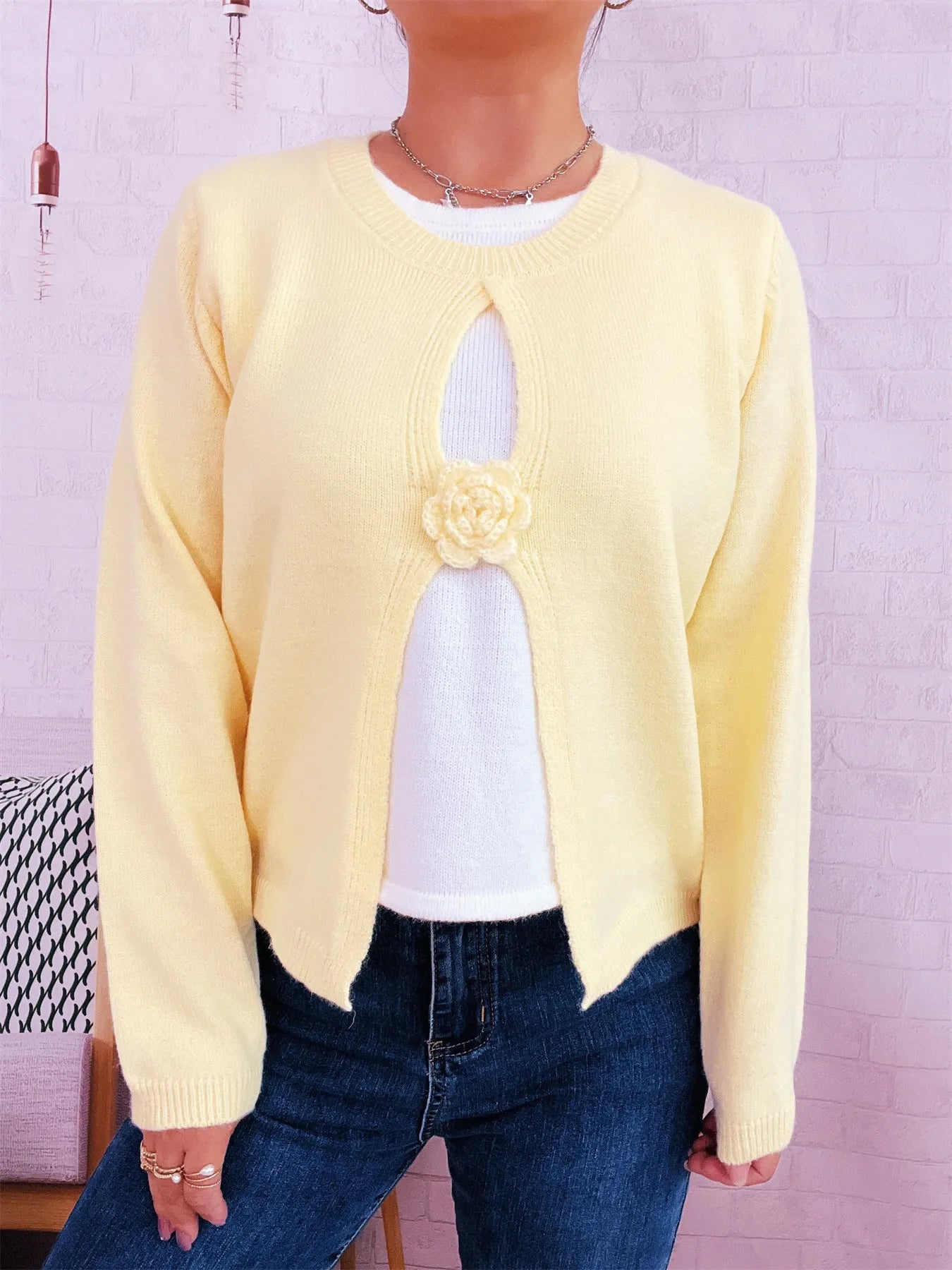 Cream round-neck sweater with white contrast front panel and floral rosette appliqué