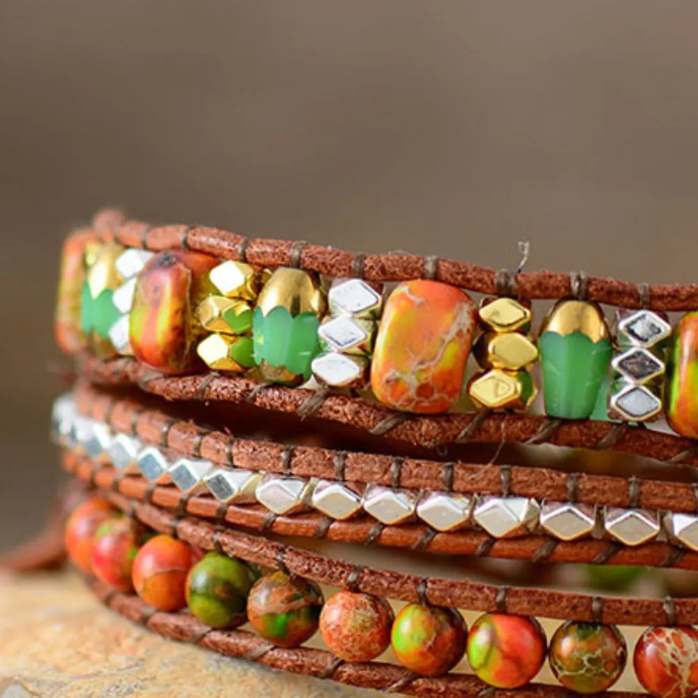 Natural stone woven bracelet close-up with orange, green stones and gold metal beads