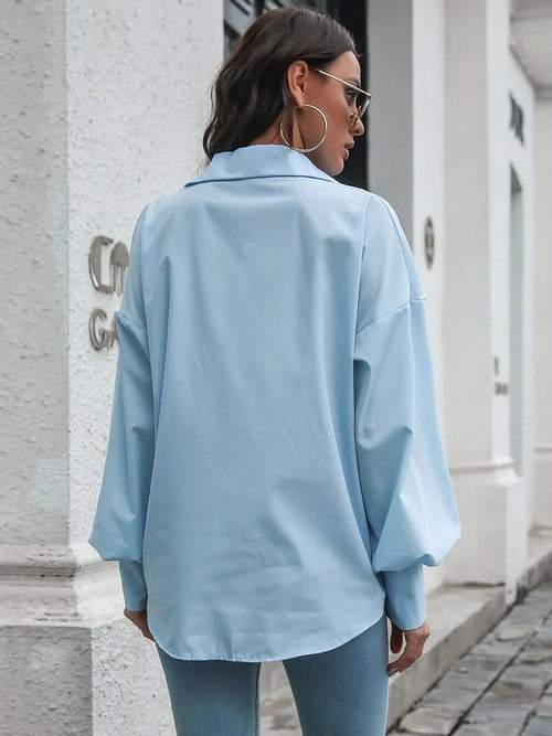 Light blue button-up shirt from back view with dropped shoulders and lantern sleeves.