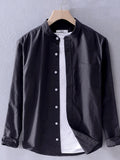 Long-sleeve button-up shirt in dark black with front button placket and breast pocket