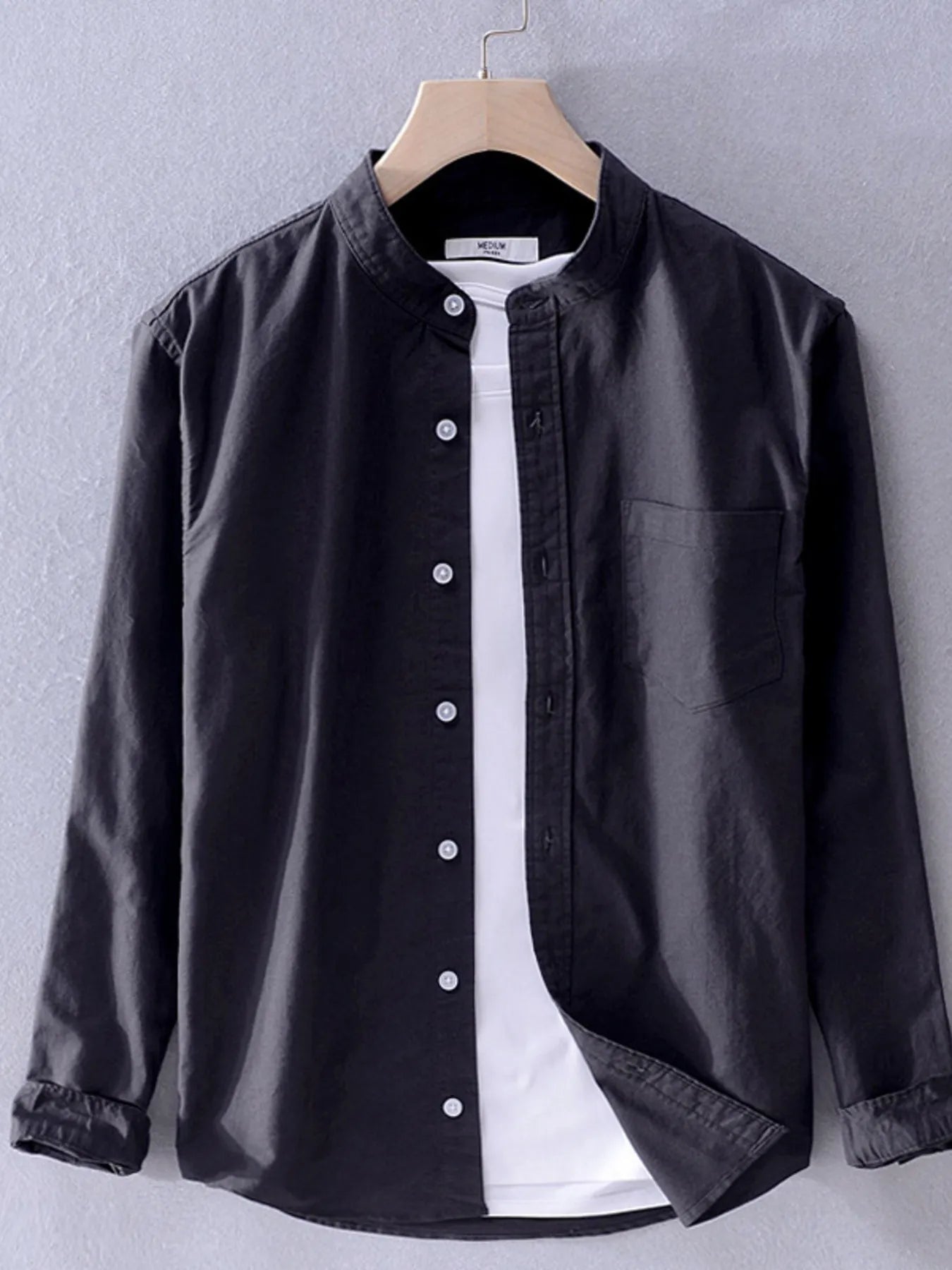 Long-sleeve button-up shirt in dark black with front button placket and breast pocket