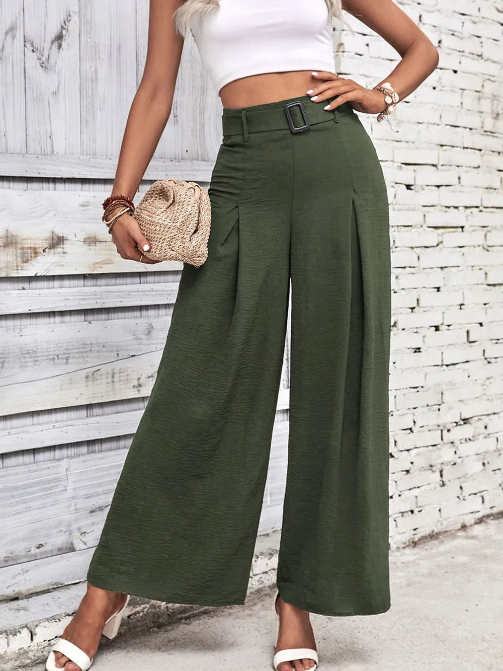 High-waisted wide-leg pants in deep green with belt and wide, flowing legs.