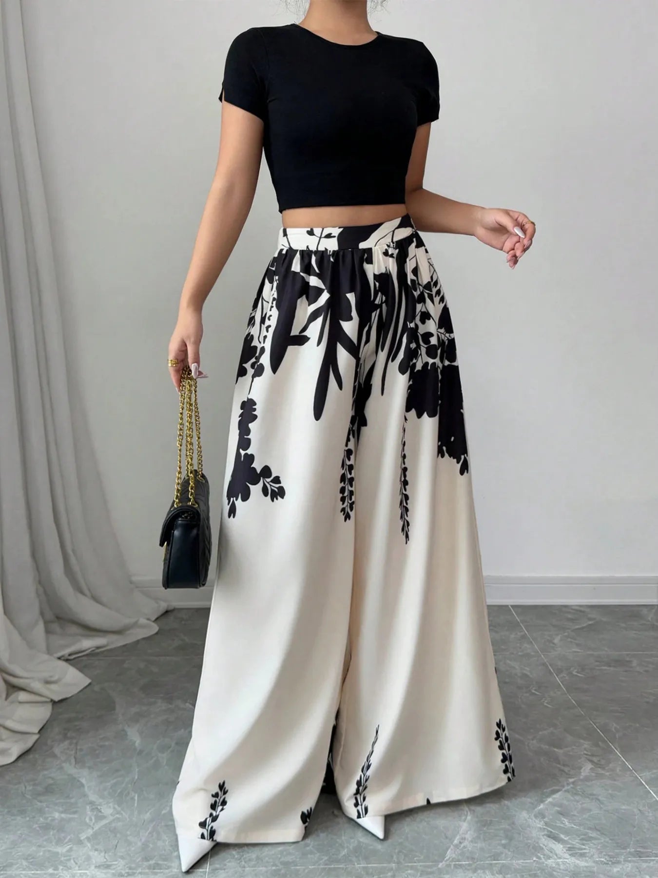 White and black printed wide-leg pants with elastic waist and drawstring, floral motif