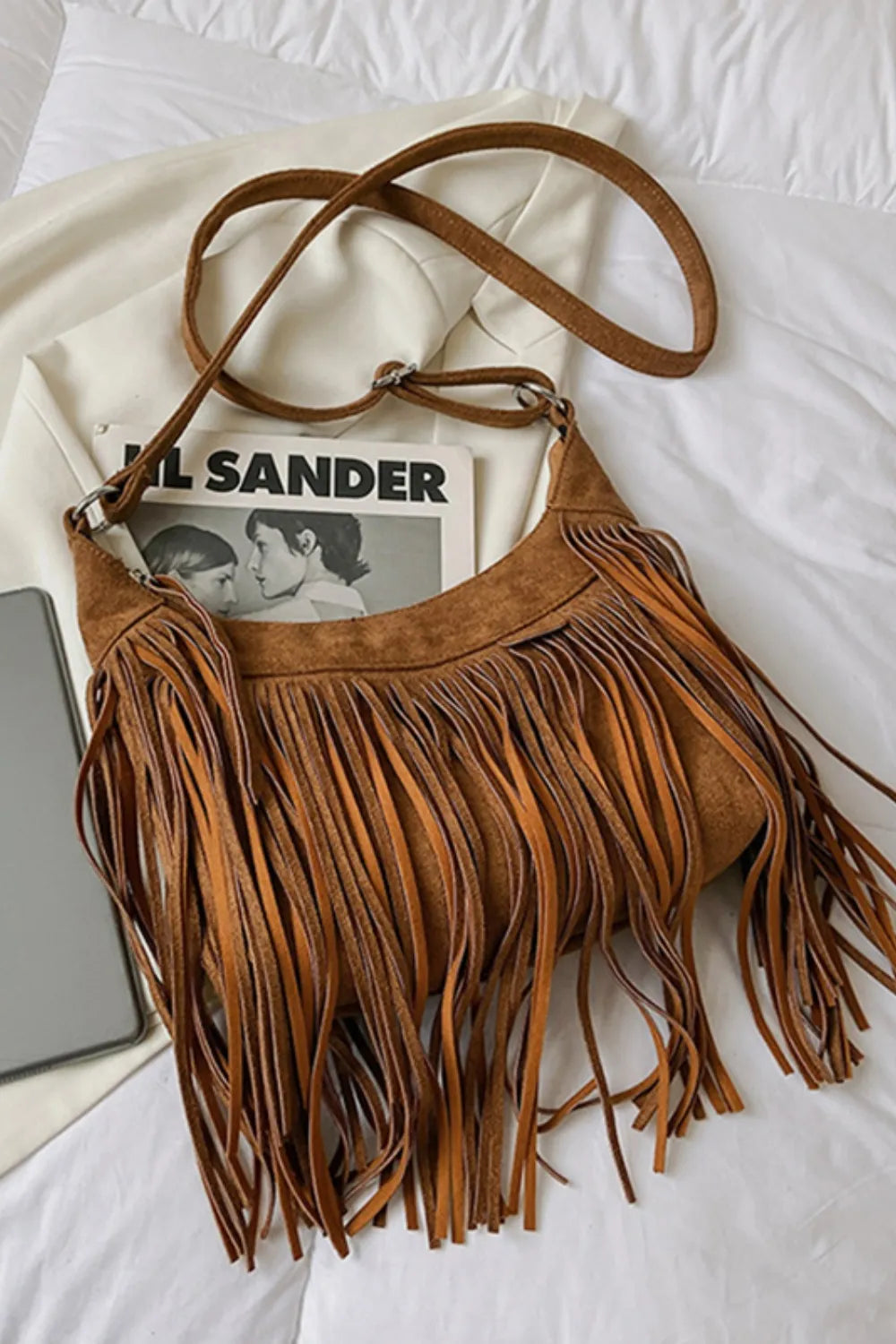 Tan suede fringe shoulder bag with adjustable crossbody strap and top zipper