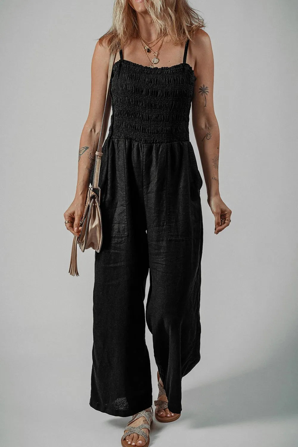 Black smocked spaghetti strap wide-leg jumpsuit, full-length front view with gathered waist